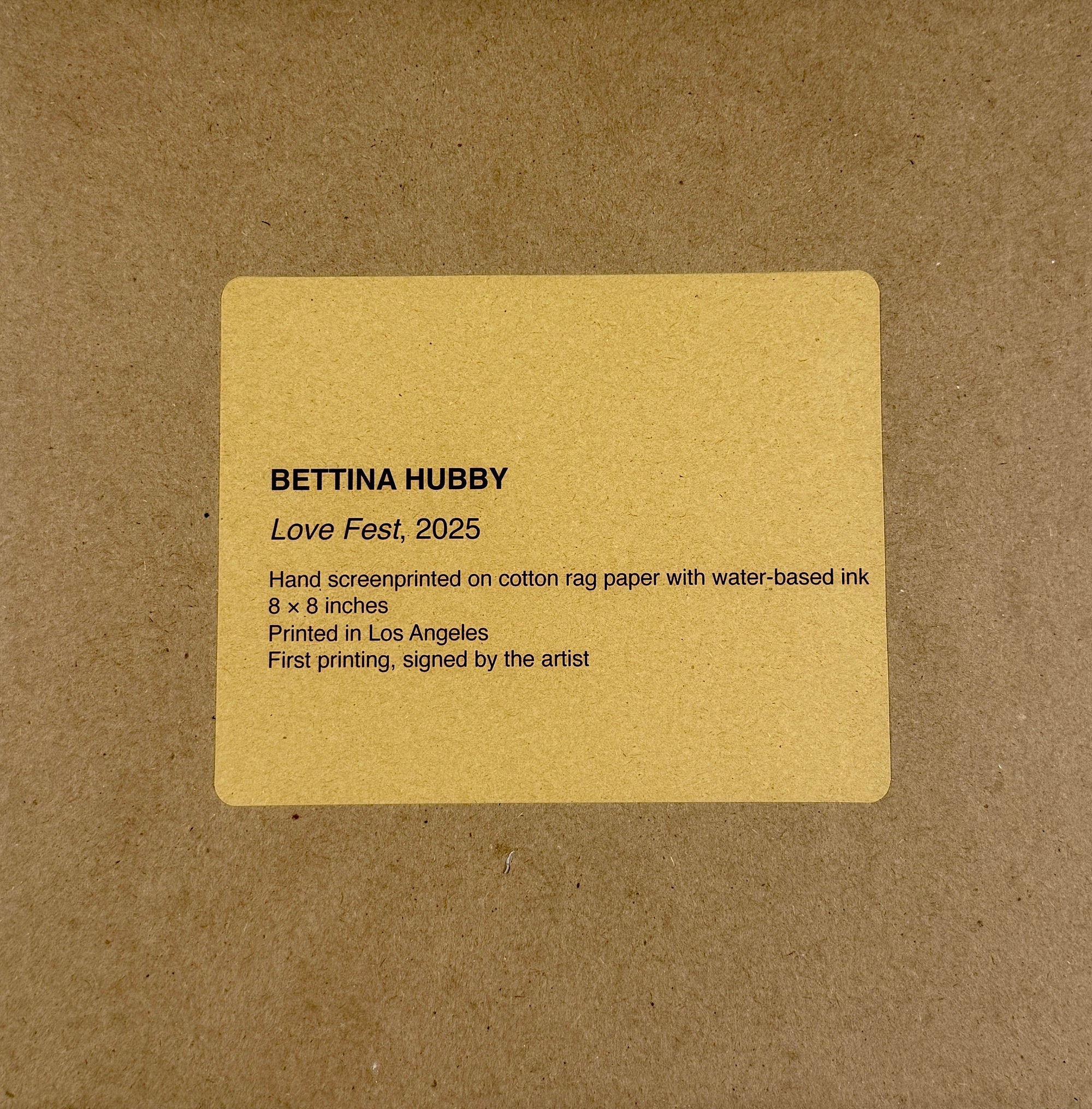 Card with text about an artist's work on a brown envelope